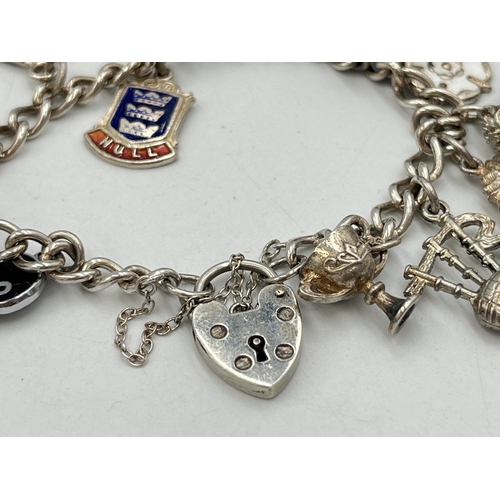 2051 - A hallmarked Birmingham sterling silver charm bracelet with heart shaped padlock clasp and assorted ... 