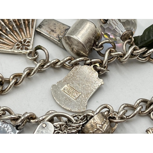 2051 - A hallmarked Birmingham sterling silver charm bracelet with heart shaped padlock clasp and assorted ... 