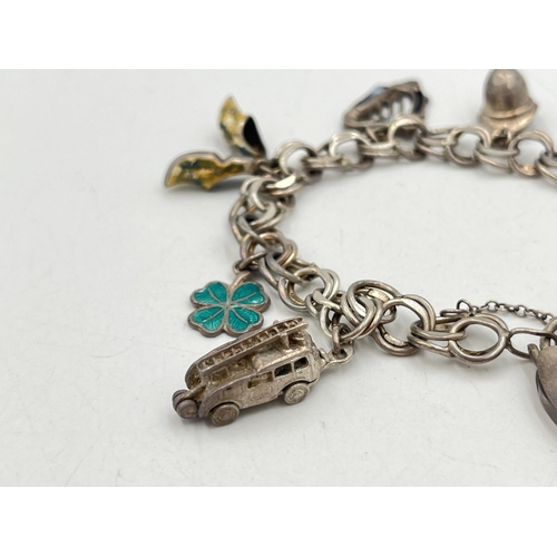 2071 - A hallmarked London sterling silver charm bracelet with heart shaped padlock clasp and assorted char... 