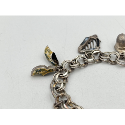 2071 - A hallmarked London sterling silver charm bracelet with heart shaped padlock clasp and assorted char... 