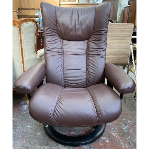 133 - An Ekornes Stressless brown leather and ebonised bentwood swivel reclining armchair and two footstoo... 