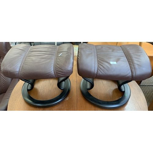 133 - An Ekornes Stressless brown leather and ebonised bentwood swivel reclining armchair and two footstoo... 