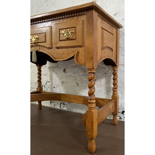 140 - A 19th century style oak three drawer writing desk on barley twist supports - approx. 76cm high x 90... 