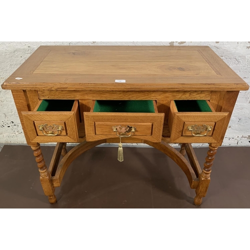 140 - A 19th century style oak three drawer writing desk on barley twist supports - approx. 76cm high x 90... 