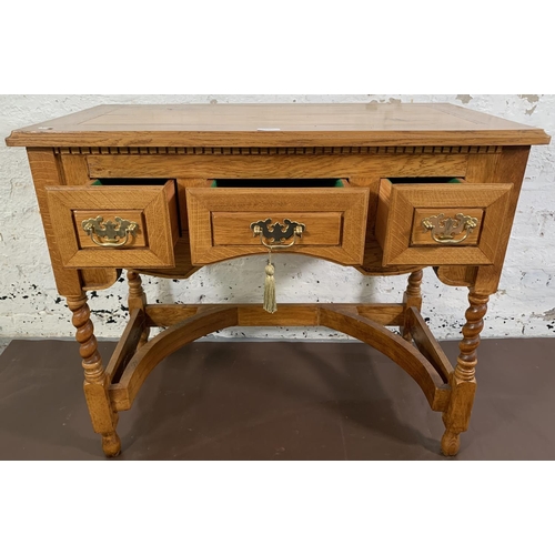 140 - A 19th century style oak three drawer writing desk on barley twist supports - approx. 76cm high x 90... 