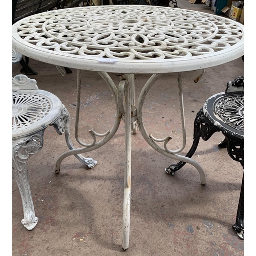 144 - A Victorian style cast metal three piece patio set comprising circular table and two chairs - table ... 