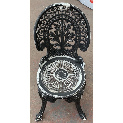 144 - A Victorian style cast metal three piece patio set comprising circular table and two chairs - table ... 