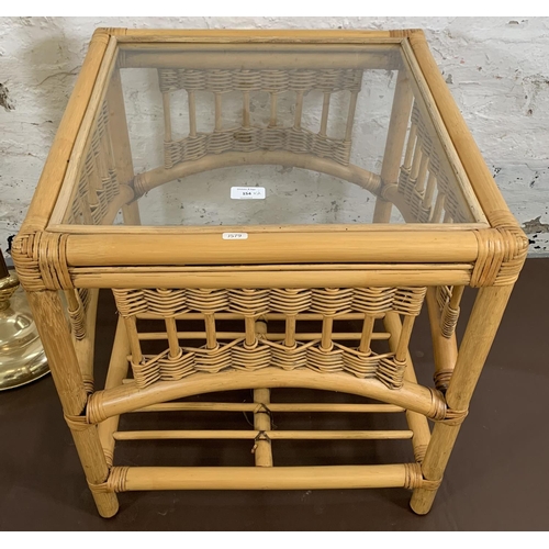 154 - Two items, one wicker and cane square side table with glass top and one brass effect uplighter floor... 