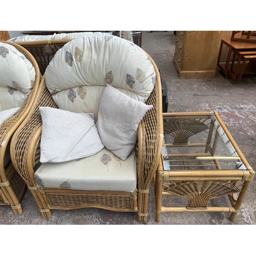 75 - A modern wicker and cane four piece conservatory suite comprising two seater sofa, two armchairs and... 