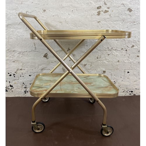 110 - A mid 20th century onyx effect laminate and metal two tier tea trolley