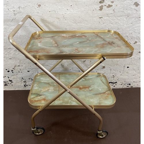 110 - A mid 20th century onyx effect laminate and metal two tier tea trolley