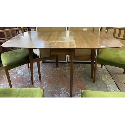 113 - A mid 20th century walnut and beech drop leaf gate leg dining table and six green fabric upholstered... 