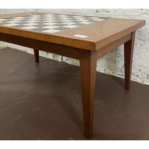 114 - A mid 20th century teak rectangular games table with ceramic tile inserts - approx. 34cm high x 45cm... 