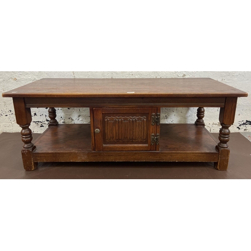 121 - An Old Charm carved oak rectangular coffee table with linenfold cupboard door - approx. 46cm high x ... 