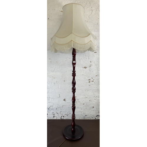 124 - A late 20th century mahogany effect standard lamp with circular base - approx. 150cm high excluding ... 