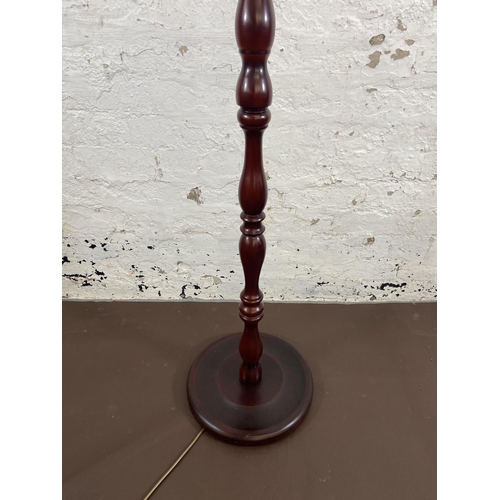 124 - A late 20th century mahogany effect standard lamp with circular base - approx. 150cm high excluding ... 