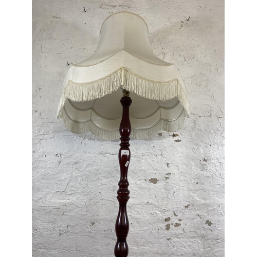 124 - A late 20th century mahogany effect standard lamp with circular base - approx. 150cm high excluding ... 