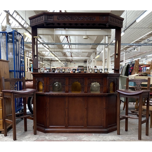 An Old Charm carved oak drinks bar with two stools and thirteen optics - approx. 191cm high x 155cm wide x 40cm deep