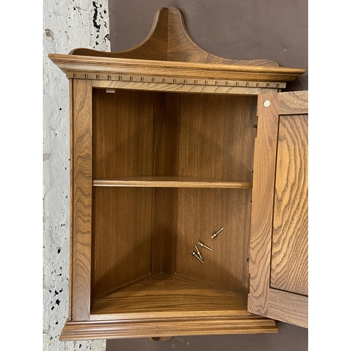 29 - An Ercol Golden Dawn elm wall mountable corner cabinet - approx. 104cm high