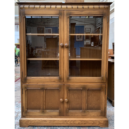 33 - An Ercol Golden Dawn elm glazed bookcase - approx. 138cm high x 100cm wide x 30cm deep