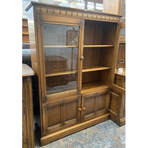 33 - An Ercol Golden Dawn elm glazed bookcase - approx. 138cm high x 100cm wide x 30cm deep