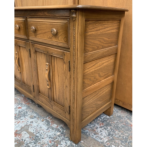 34 - An Ercol Golden Dawn elm sideboard - approx. 86cm high x 143cm wide x 52cm deep