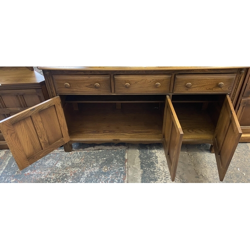 34 - An Ercol Golden Dawn elm sideboard - approx. 86cm high x 143cm wide x 52cm deep