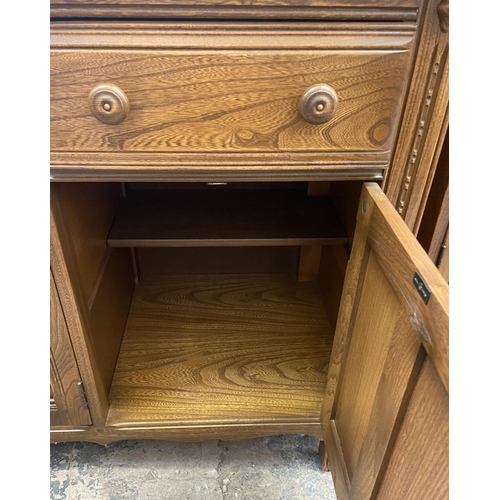 34 - An Ercol Golden Dawn elm sideboard - approx. 86cm high x 143cm wide x 52cm deep