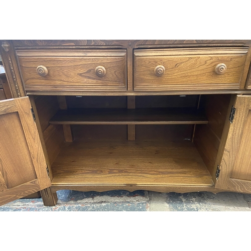 34 - An Ercol Golden Dawn elm sideboard - approx. 86cm high x 143cm wide x 52cm deep