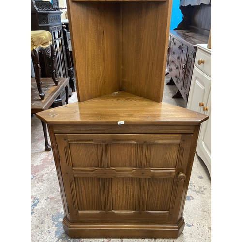 37 - An Ercol Golden Dawn elm free standing corner cabinet - approx. 196cm high