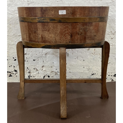 47 - A coopered oak and metal banded planter on wooden stand bearing label 