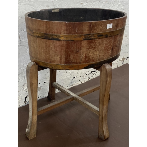 47 - A coopered oak and metal banded planter on wooden stand bearing label 