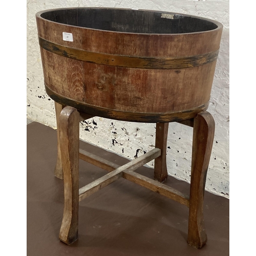 47 - A coopered oak and metal banded planter on wooden stand bearing label 