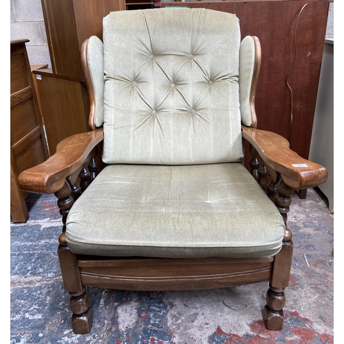 54 - A beech and green fabric button back upholstered armchair and footstool