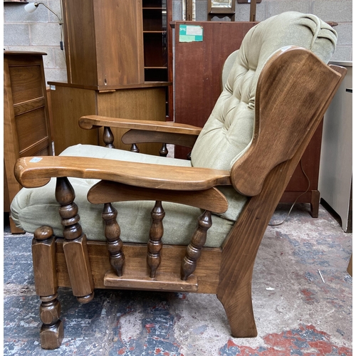 54 - A beech and green fabric button back upholstered armchair and footstool