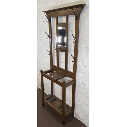 6 - An Arts & Crafts oak hall stand with central bevelled edge mirror and six coat hooks - approx. 185cm... 