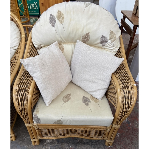 75 - A modern wicker and cane four piece conservatory suite comprising two seater sofa, two armchairs and... 