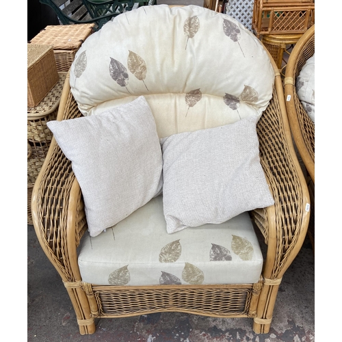 75 - A modern wicker and cane four piece conservatory suite comprising two seater sofa, two armchairs and... 