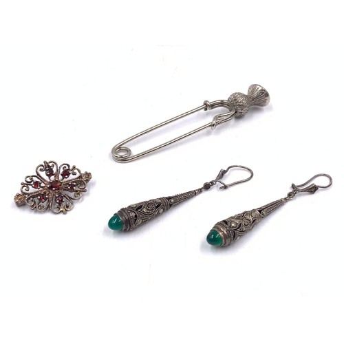 2094 - Three pieces of gemstone set jewellery, one white metal thistle kilt pin, one silver garnet brooch a... 