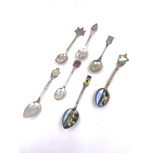 2104 - Seven silver and white metal collector's spoons to include Indian silver, Canadian sterling and enam... 