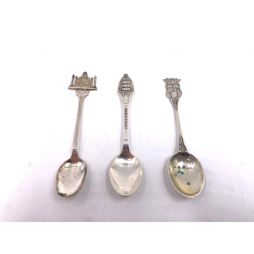 2104 - Seven silver and white metal collector's spoons to include Indian silver, Canadian sterling and enam... 