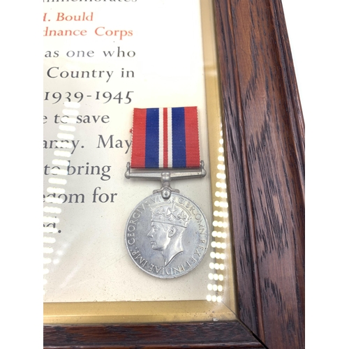 2245 - An oak framed WWII four piece medal group with scroll presented to Corporal H. Bould Royal Army Ordn... 