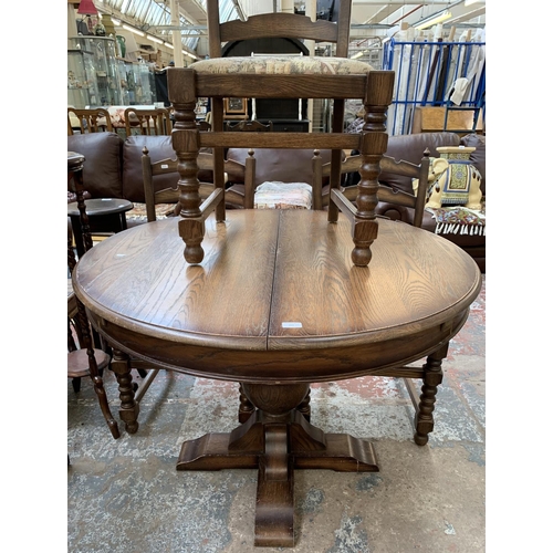 161 - An oak circular extending table on carved baluster support and four chairs - approx. 78cm high x 110... 