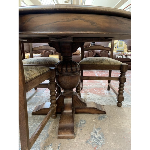 161 - An oak circular extending table on carved baluster support and four chairs - approx. 78cm high x 110... 