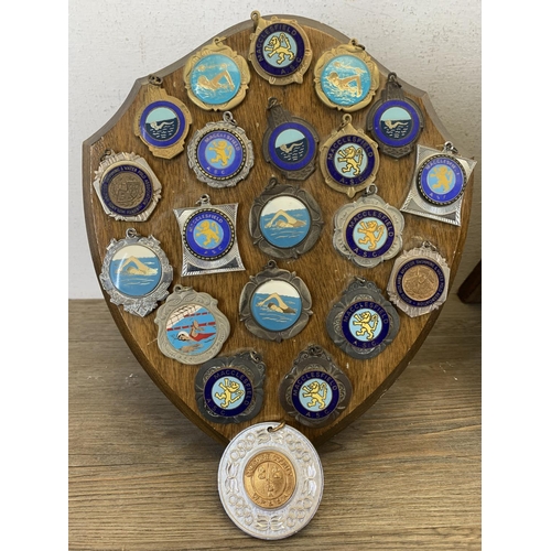 514 - Two vintage carved oak shield frames with a large collection of Macclesfield amateur swimming club m... 