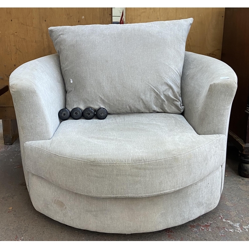 252 - A modern grey fabric upholstered swivel armchair