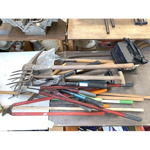 1059 - A collection of garden hand tools to include pickaxe, pitch fork, shovel etc.