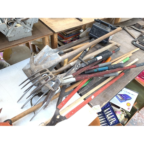 1059 - A collection of garden hand tools to include pickaxe, pitch fork, shovel etc.