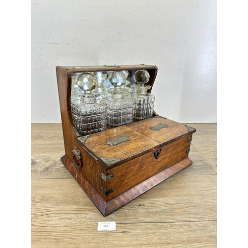 519 - A 19th century oak tantalus with three cut glass decanters - approx. 30cm high x 33cm wide x 27cm de... 