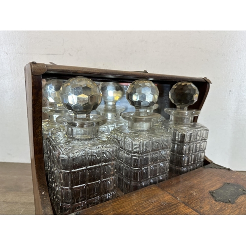 519 - A 19th century oak tantalus with three cut glass decanters - approx. 30cm high x 33cm wide x 27cm de... 